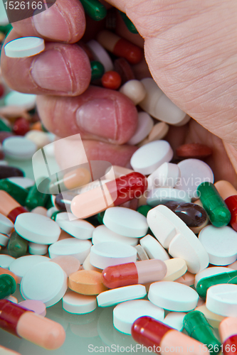 Image of hand grabbing pills