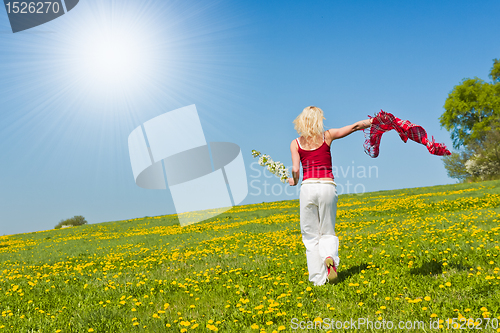 Image of young woman with a red scarf on a meadow