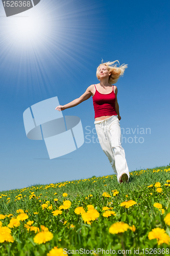 Image of young woman in red outfit having fun on meadow