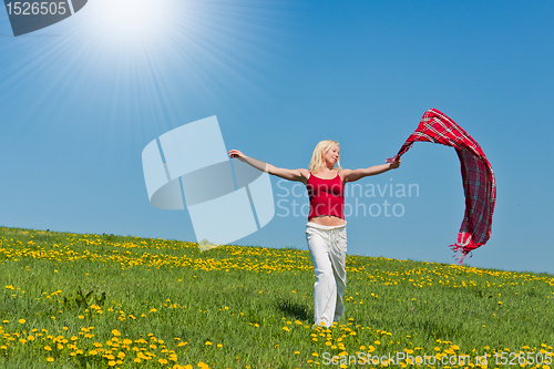Image of young woman with a red scarf on a meadow