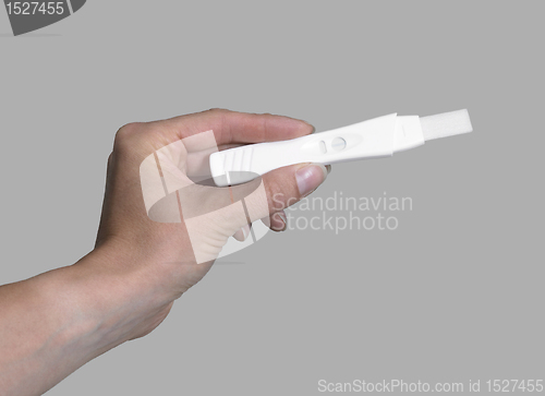 Image of hand holding a pregnancy test