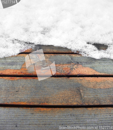 Image of partly snow covered wooden boards