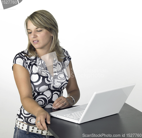 Image of cute blond girl turns away from laptop