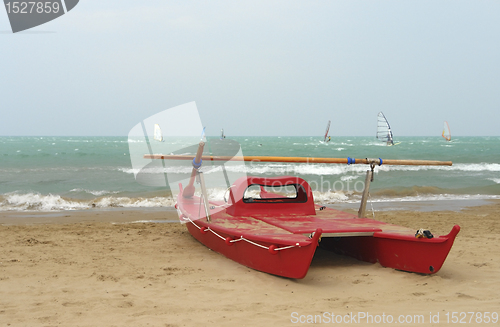 Image of red catamaran at the beach