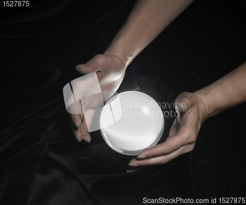 Image of crystal ball and hands around