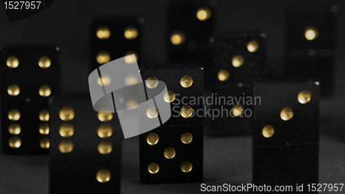 Image of black dominoes with golden spots