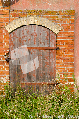 Image of Abandoned farm house door lock red brick building