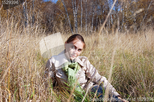 Image of woman in the grass. autumn day