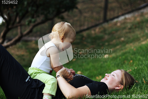 Image of Mother with sone play on a grass