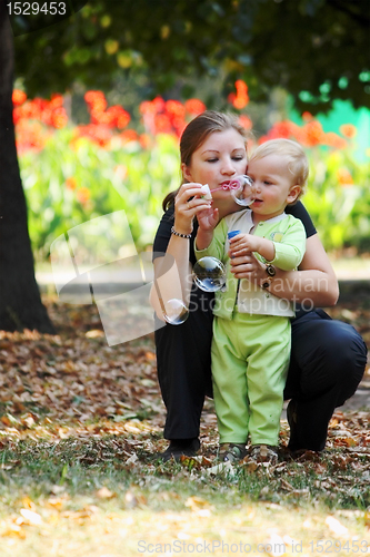 Image of Family in park blows bubbles