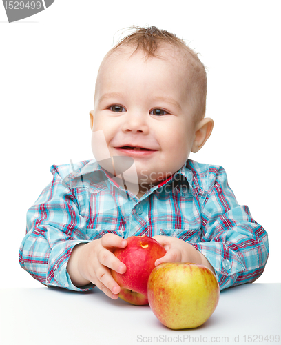 Image of Little child is eating red apple