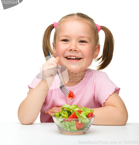 Image of Cute little girl eats vegetable salad