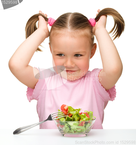 Image of Cute little girl eats vegetable salad