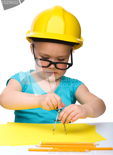 Image of Little girl is playing while wearing hard hat