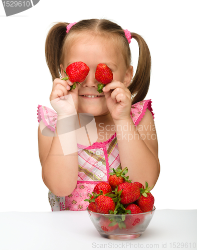 Image of Happy little girl with strawberries