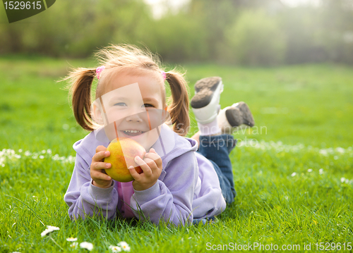 Image of Little girl is laying on green meadow