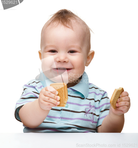Image of Cute little boy is holding cookies and smile