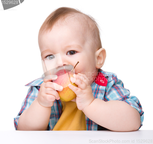 Image of Little child is eating red apple