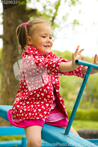 Image of Cute little girl is swinging on see-saw