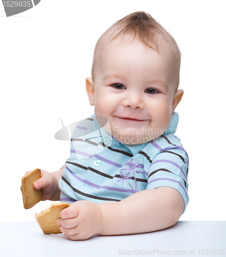 Image of Cute little boy is holding cookies and smile