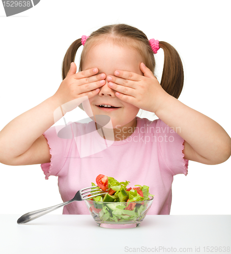 Image of Cute little girl eats vegetable salad