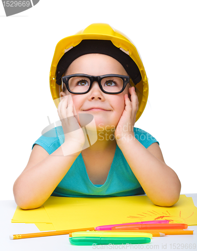 Image of Cute little girl is playing while wearing hard hat