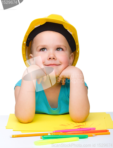 Image of Cute little girl is playing while wearing hard hat