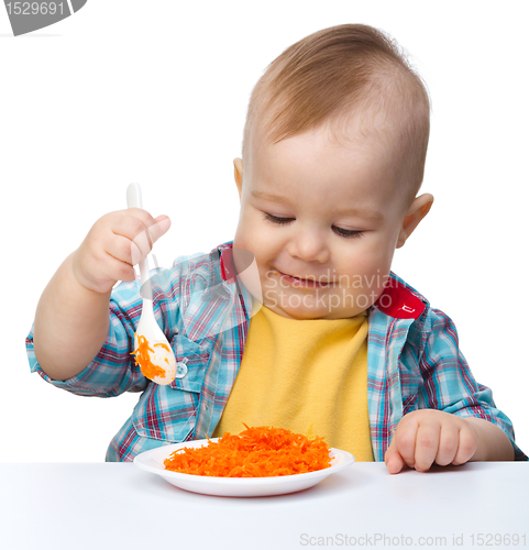 Image of Cute little boy is playing with carrot salad
