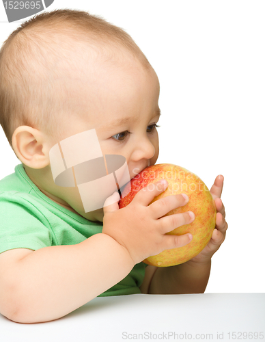 Image of Little child is eating red apple