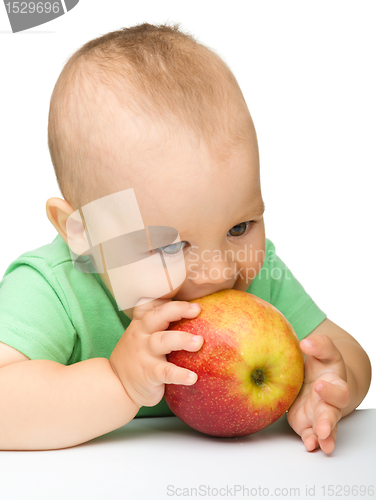 Image of Little child is eating red apple