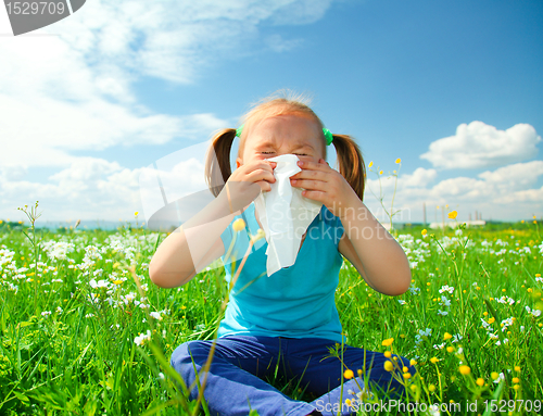 Image of Little girl is blowing her nose