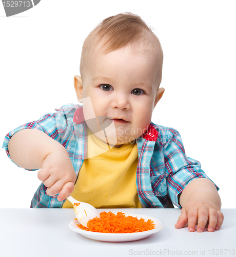 Image of Cute little boy is playing with carrot salad