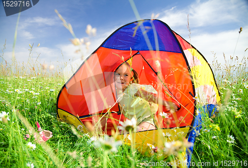 Image of Girl is playing outdoors under tent