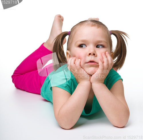 Image of Portrait of a cute little girl laying on floor