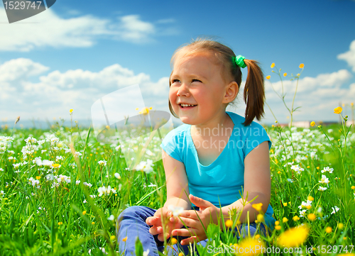 Image of Little girl is playing on green meadow