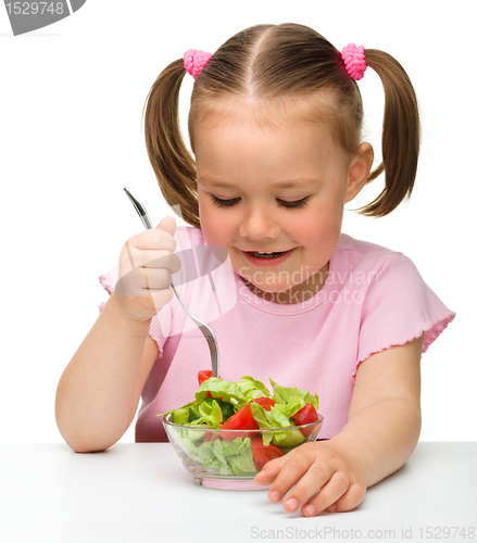 Image of Cute little girl eats vegetable salad