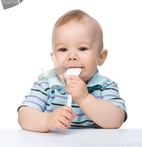 Image of Cute little boy is biting spoon
