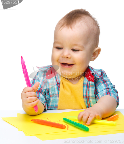 Image of Happy little boy is playing with colorful markers