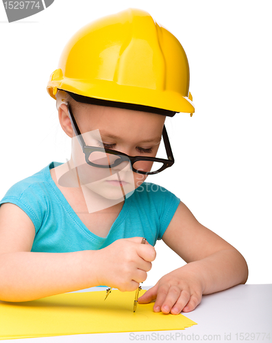 Image of Little girl is playing while wearing hard hat