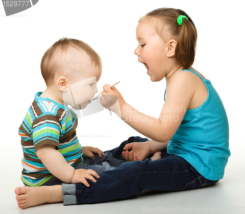 Image of Sister is feeding her little brother