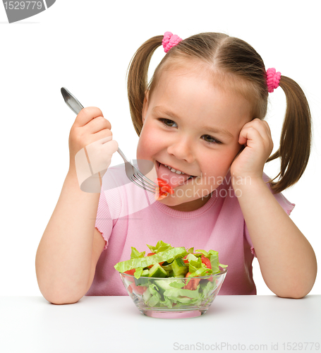 Image of Cute little girl eats vegetable salad