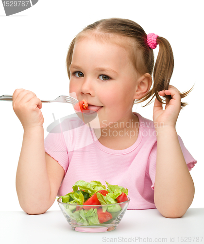 Image of Cute little girl eats vegetable salad