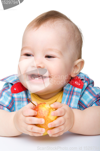 Image of Little child is eating red apple and smile