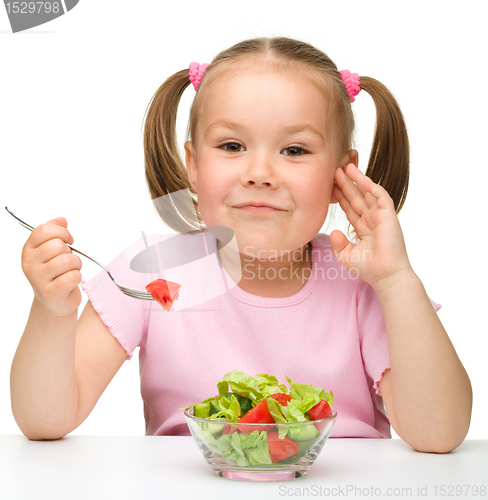 Image of Cute little girl eats vegetable salad