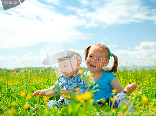 Image of Two children are having fun on green meadow