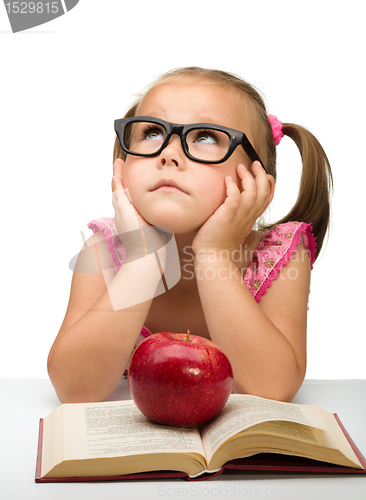 Image of Little girl is sitting bored with a book