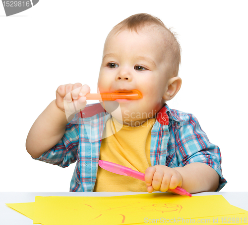 Image of Happy little boy is playing with colorful markers