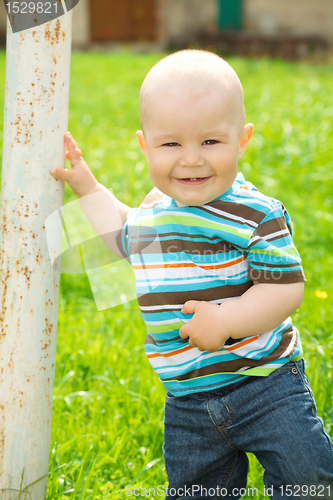 Image of Little boy is playing on green meadow