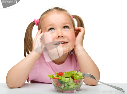 Image of Cute little girl eats vegetable salad