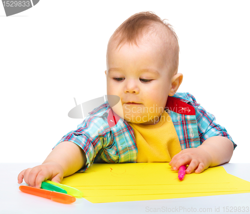 Image of Happy little boy is playing with colorful markers